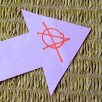 Zielrichtung Papierpfeil mit Anarchie-Logo